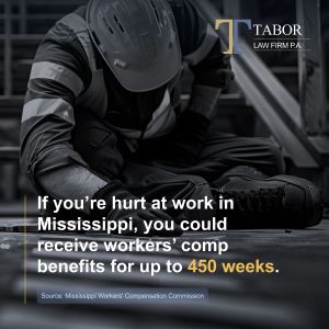 Construction worker kneeling in pain – Mississippi workers’ compensation lawyer.